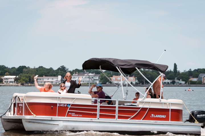 Family enjoying a pontoon boat rental at Dewey Beach Watersports