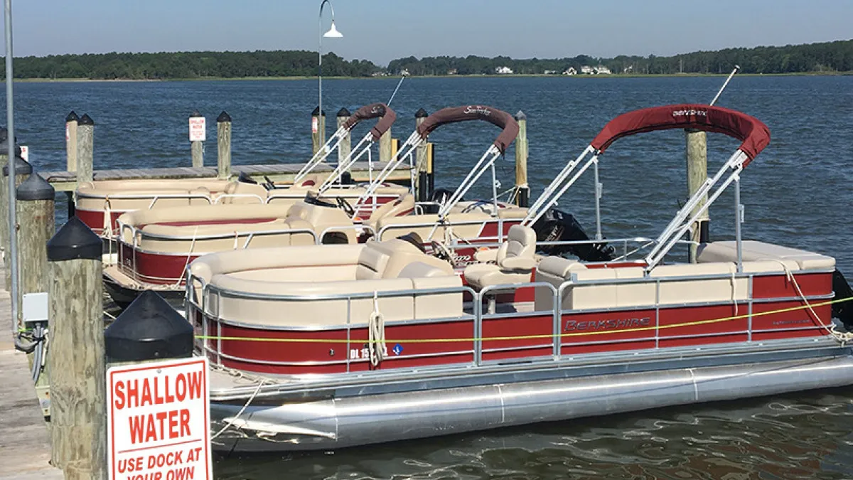 a pontoon boat in a body of water boat rental dewey rehoboth lewes bethany beach
